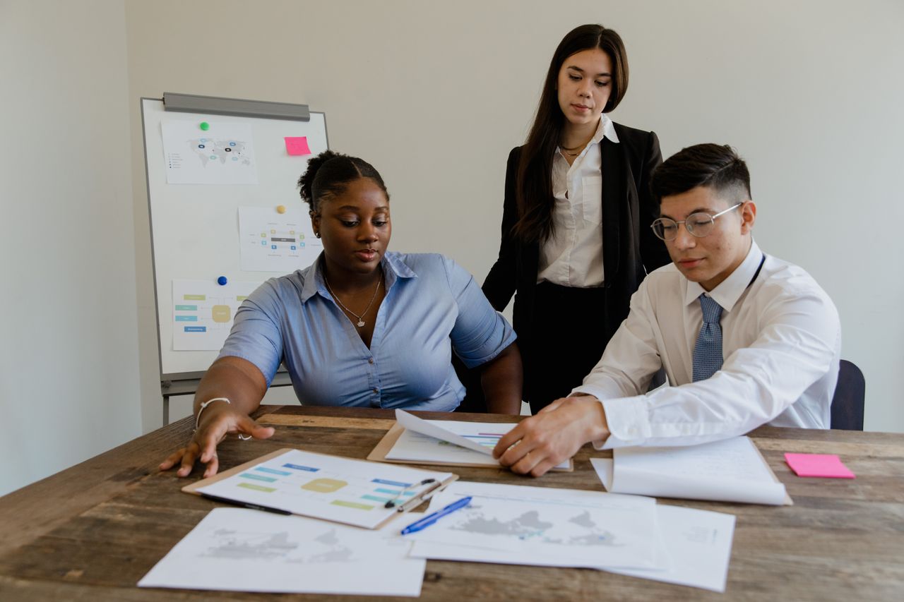 A diverse team discusses business strategies and processes in a modern office space.